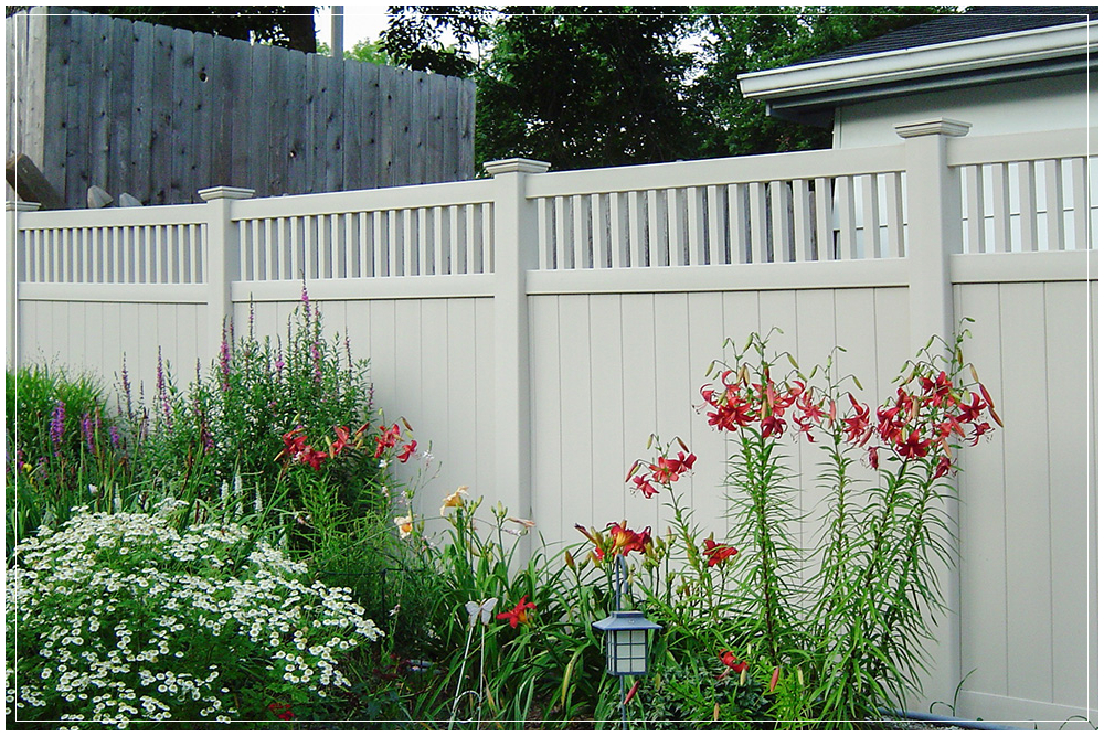 A beautiful vinyl fence lining the Ohio property with some landscaping by it.